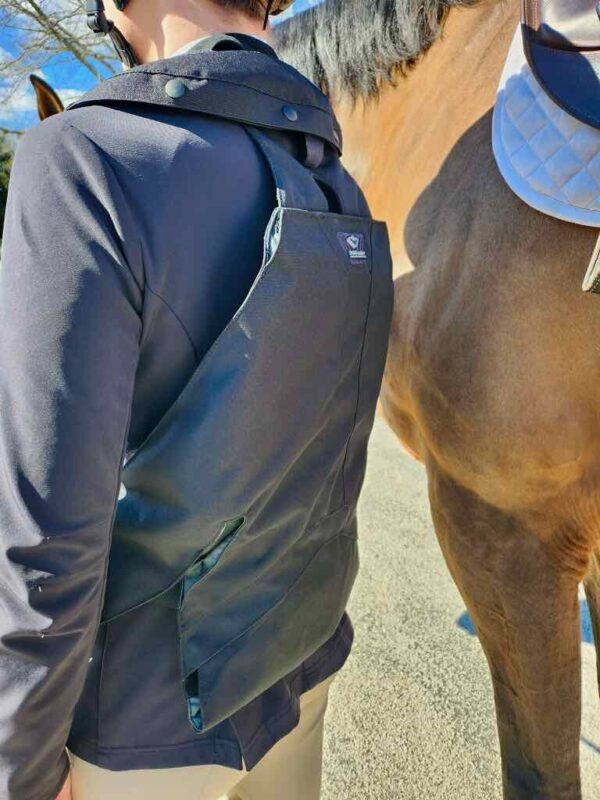 A person wearing a backpack and standing next to a horse.