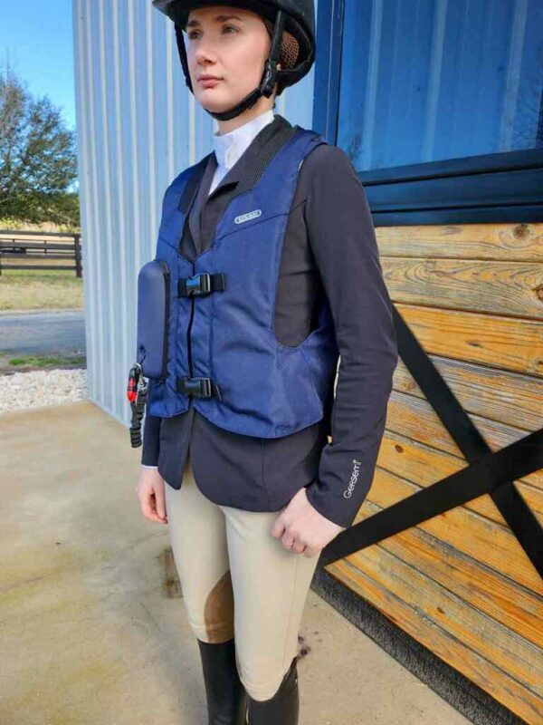 A man standing outside wearing a blue vest.