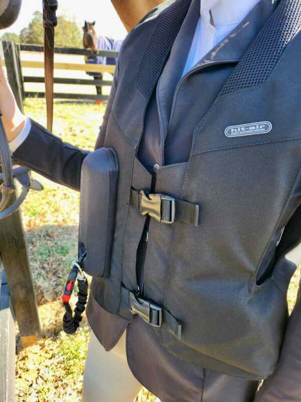 A man in a suit and tie holding onto a camera.